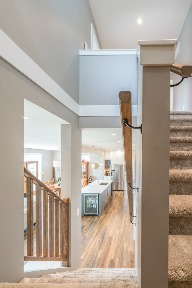Idée de décoration pour un escalier minimaliste en L de taille moyenne avec des marches en moquette, des contremarches en moquette et un garde-corps en bois.