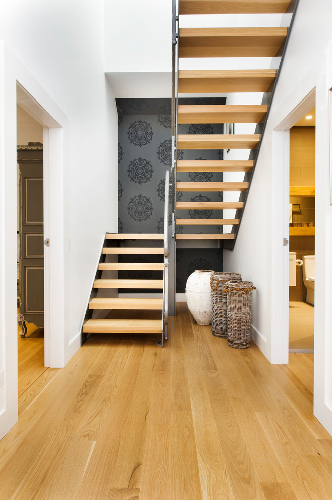 Inspiration for a contemporary wood u-shaped metal railing staircase in Sydney with a feature wall.