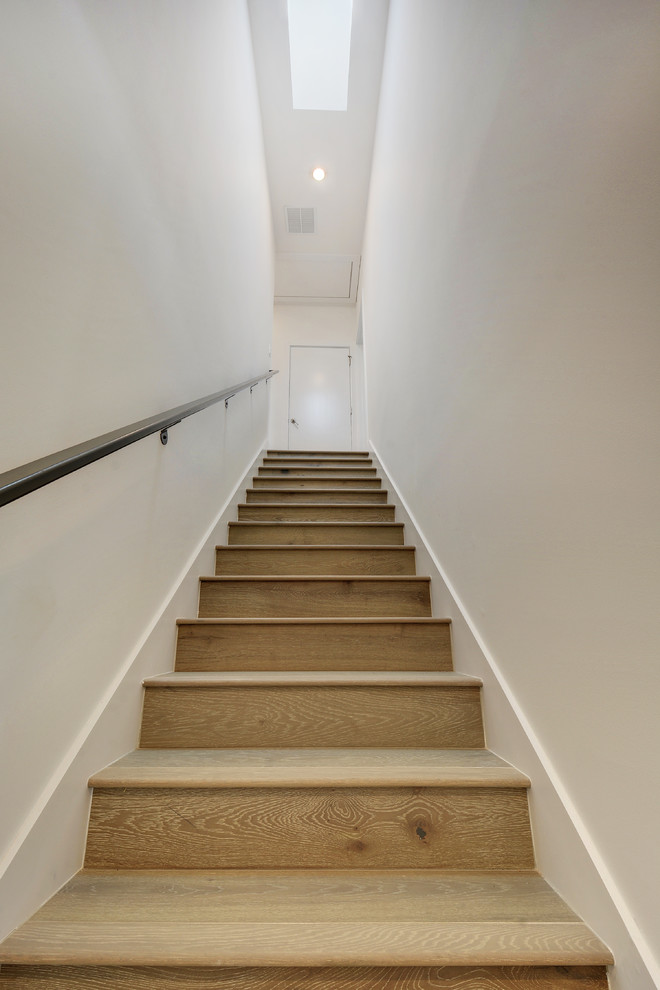This is an example of a modern wood straight metal railing staircase in Austin with wood risers.
