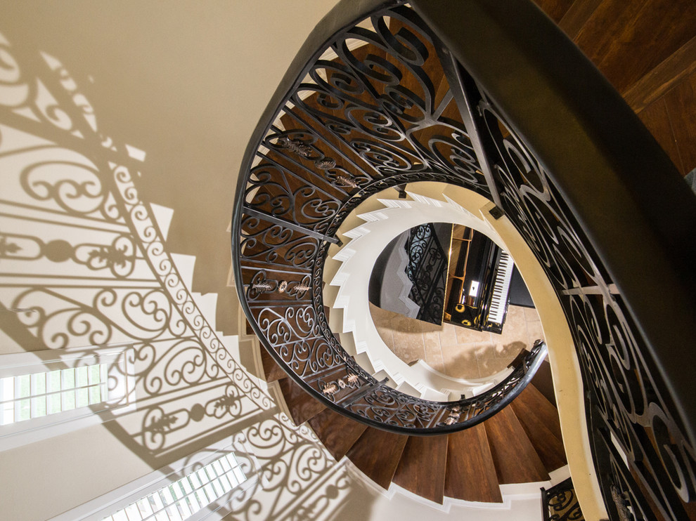 На фото: огромная винтовая металлическая лестница в средиземноморском стиле с деревянными ступенями и металлическими перилами с