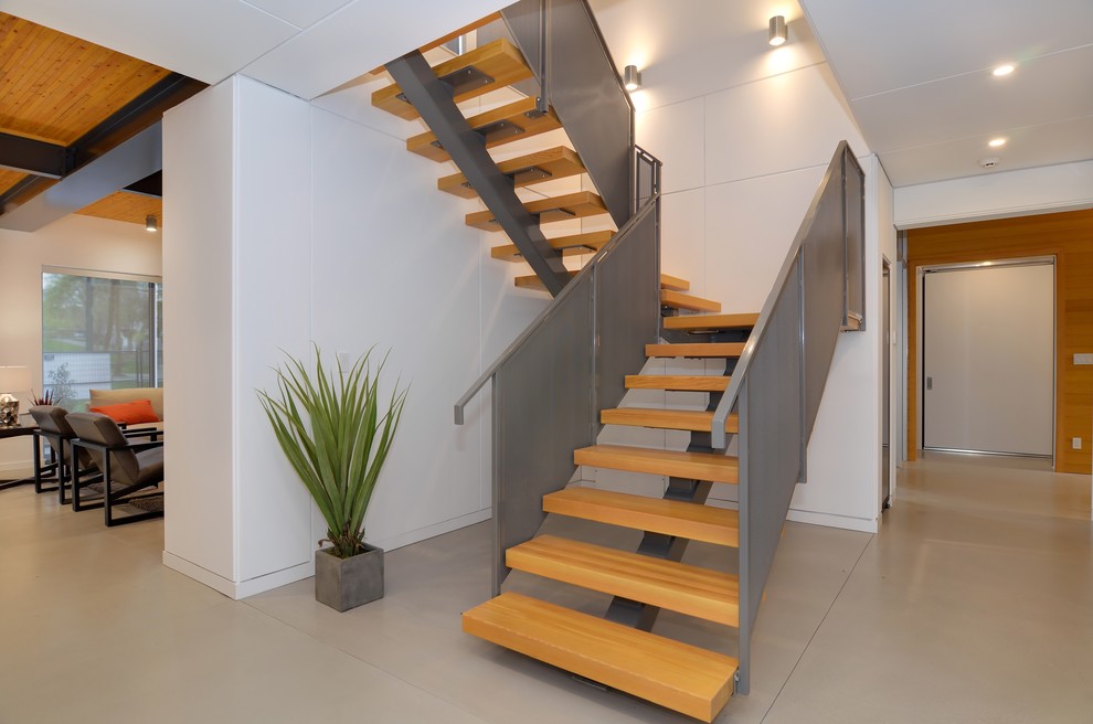 Ejemplo de escalera suspendida nórdica grande con escalones de madera y contrahuellas de metal