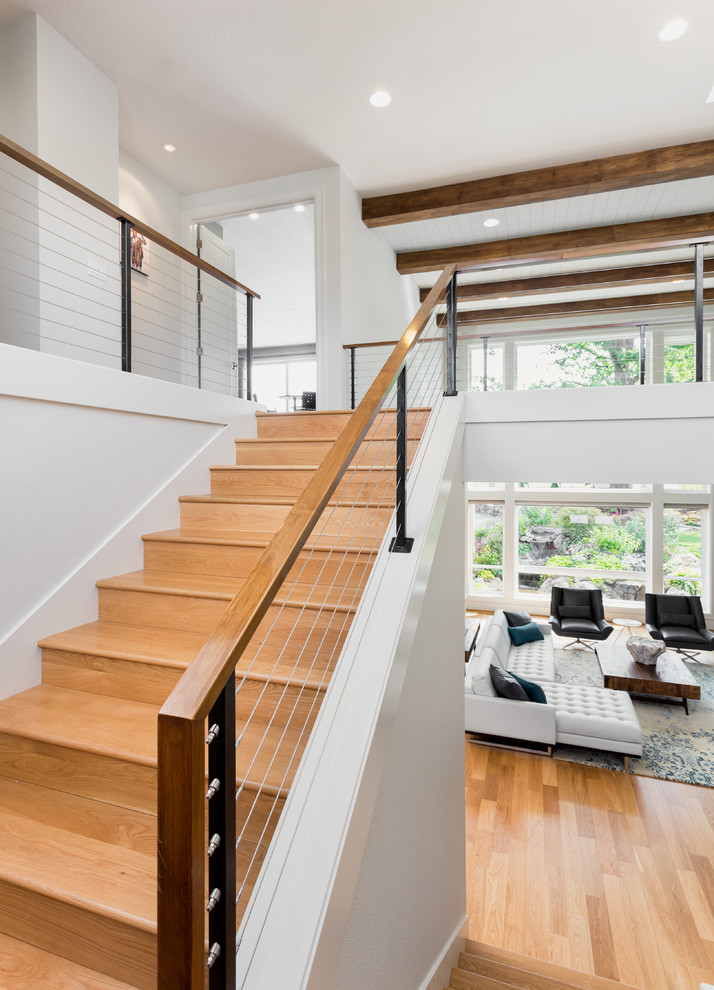 Cette image montre un grand escalier design en U avec des marches en bois et des contremarches en bois.