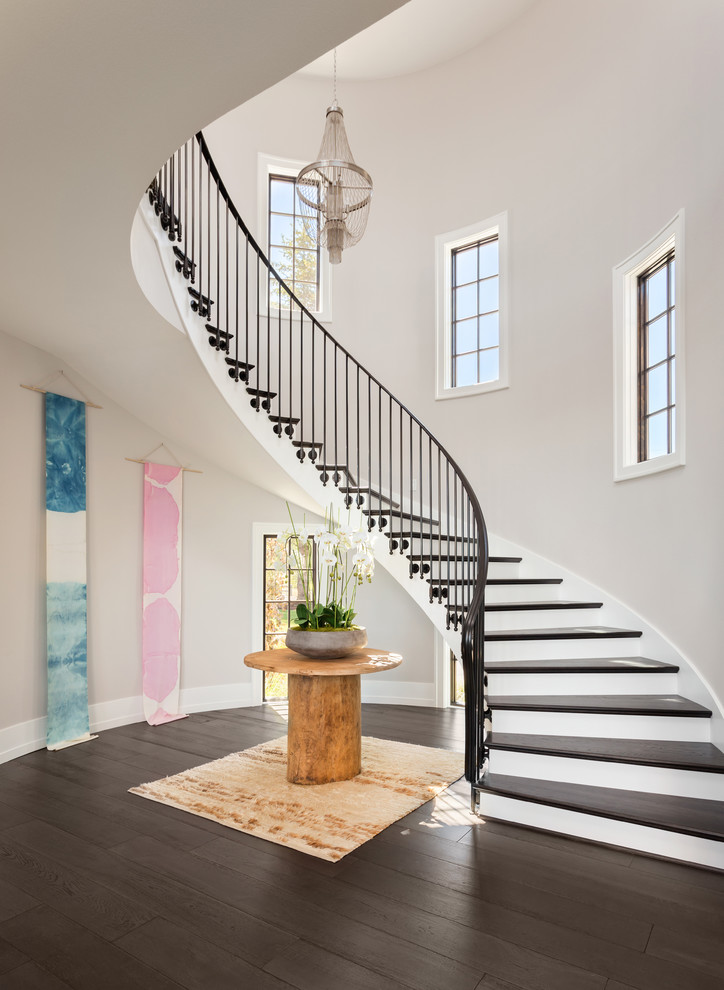 Источник вдохновения для домашнего уюта: изогнутая лестница в стиле неоклассика (современная классика) с деревянными ступенями, крашенными деревянными подступенками и металлическими перилами