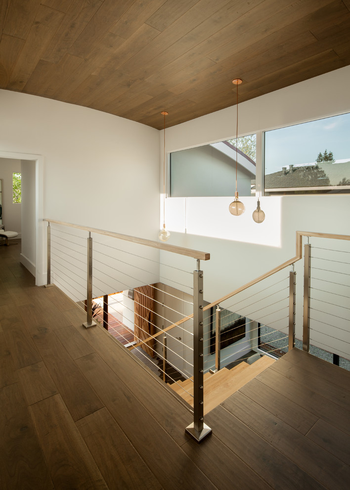Стильный дизайн: деревянная лестница на больцах, среднего размера в стиле модернизм с деревянными ступенями и металлическими перилами - последний тренд