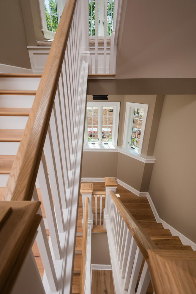 Ejemplo de escalera curva campestre extra grande con escalones de madera, contrahuellas de madera y barandilla de madera