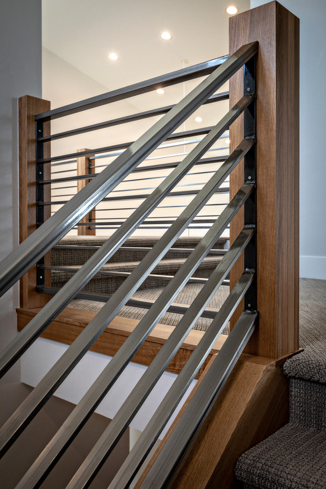 Diseño de escalera moderna con escalones enmoquetados, contrahuellas enmoquetadas y barandilla de metal