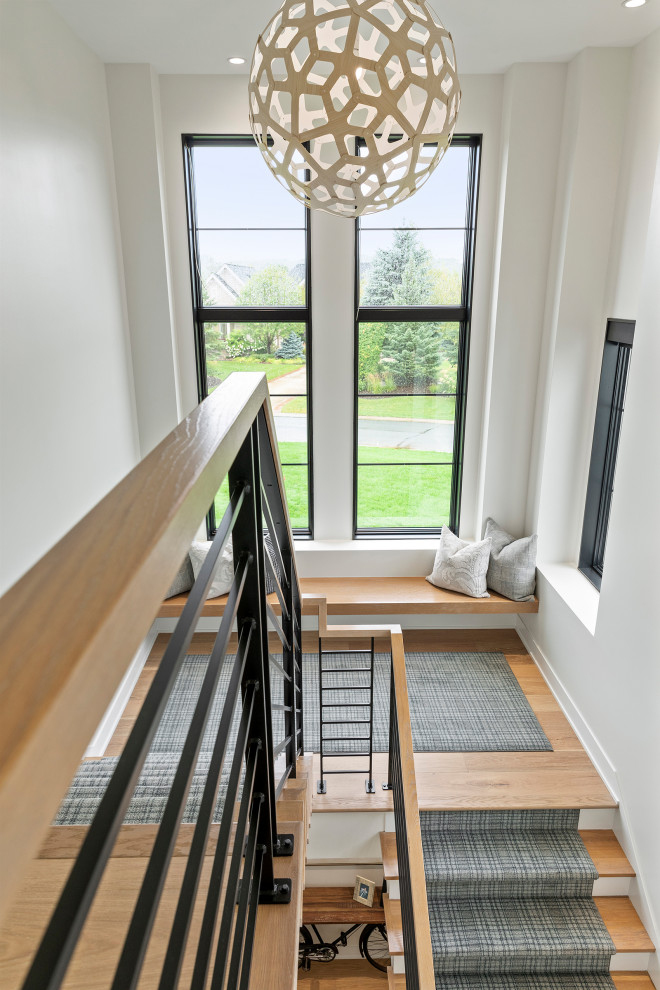 Example of a large u-shaped metal railing staircase design in Minneapolis with carpeted risers