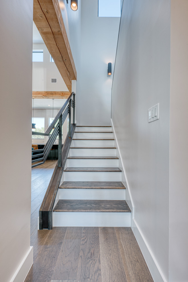 На фото: п-образная лестница среднего размера в стиле лофт с деревянными ступенями, крашенными деревянными подступенками и металлическими перилами с