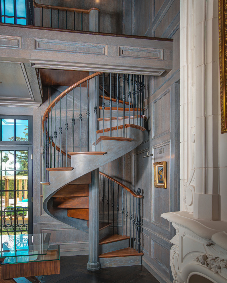 Example of a classic wooden spiral metal railing staircase design in Chicago with wooden risers