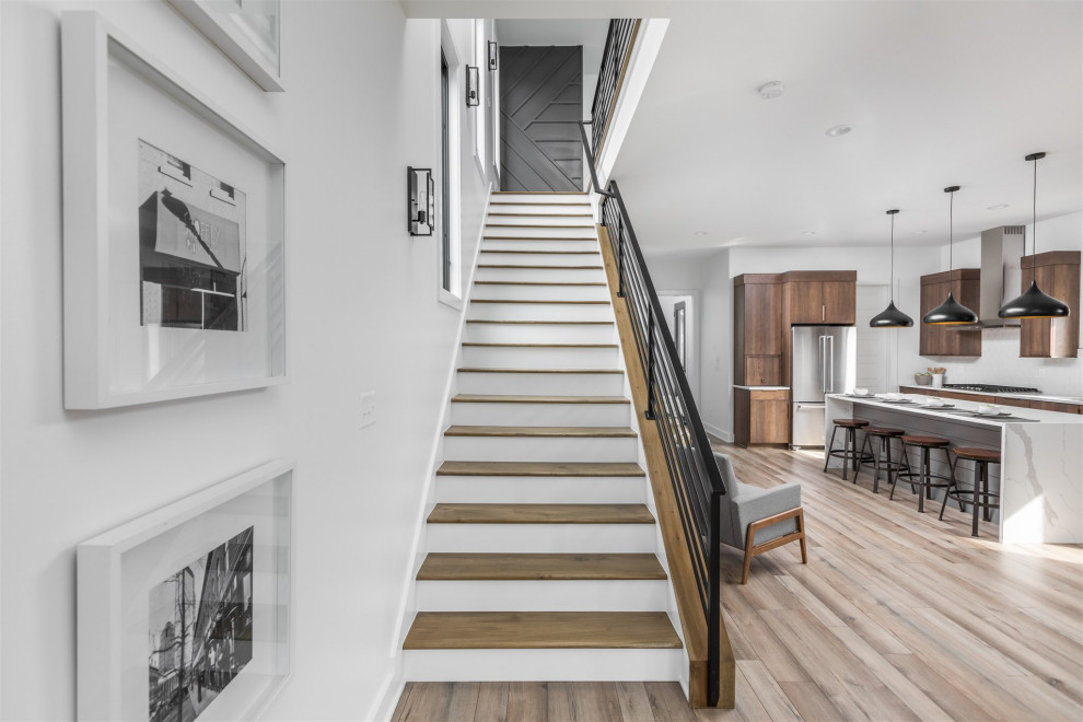 Example of a mid-sized minimalist wooden straight metal railing and wood wall staircase design in Indianapolis with wooden risers