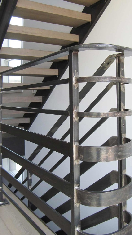 Idee per una scala a rampa dritta industriale di medie dimensioni con pedata in legno e parapetto in metallo