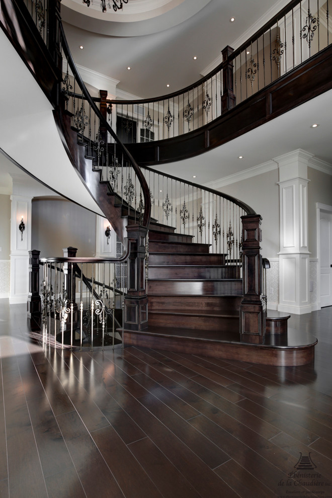 Cette image montre un grand escalier hélicoïdal traditionnel avec des marches en bois et des contremarches en bois.