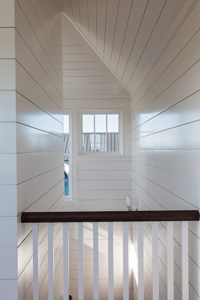 Стильный дизайн: большая лестница в морском стиле с деревянными перилами - последний тренд