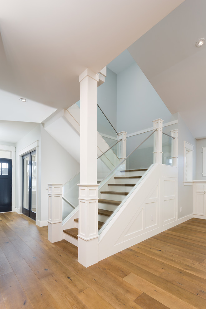 Свежая идея для дизайна: угловая деревянная лестница среднего размера в стиле модернизм с деревянными ступенями и стеклянными перилами - отличное фото интерьера