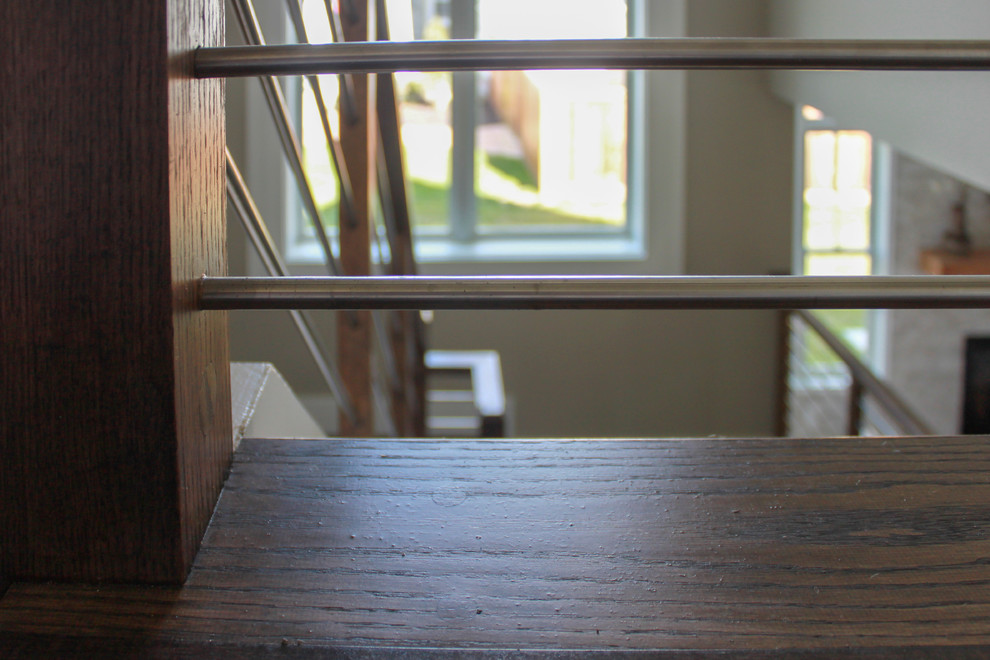 Пример оригинального дизайна: большая п-образная лестница в современном стиле с деревянными ступенями и перилами из смешанных материалов