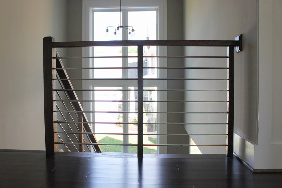 На фото: большая п-образная лестница в современном стиле с деревянными ступенями и перилами из смешанных материалов