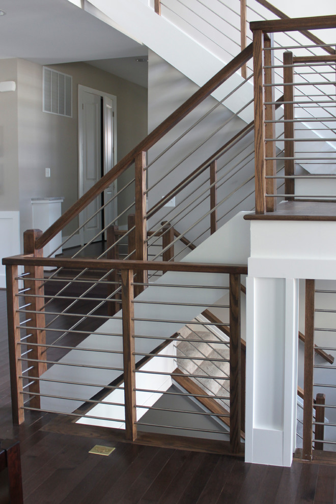 Idée de décoration pour un grand escalier design en U avec des marches en bois et un garde-corps en matériaux mixtes.