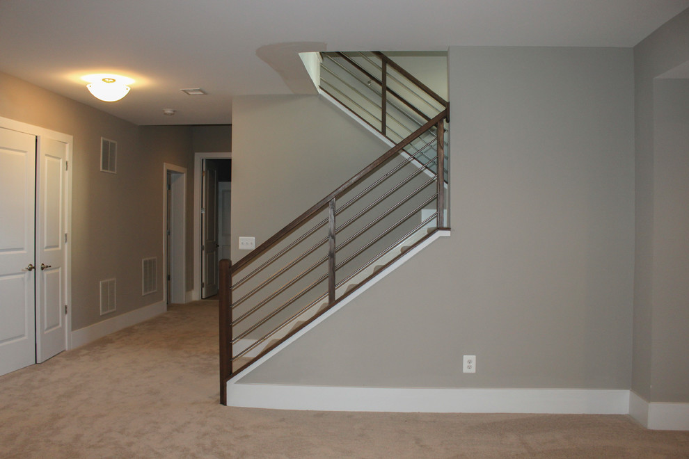 Exemple d'un grand escalier tendance en U avec des marches en bois, un garde-corps en matériaux mixtes et éclairage.