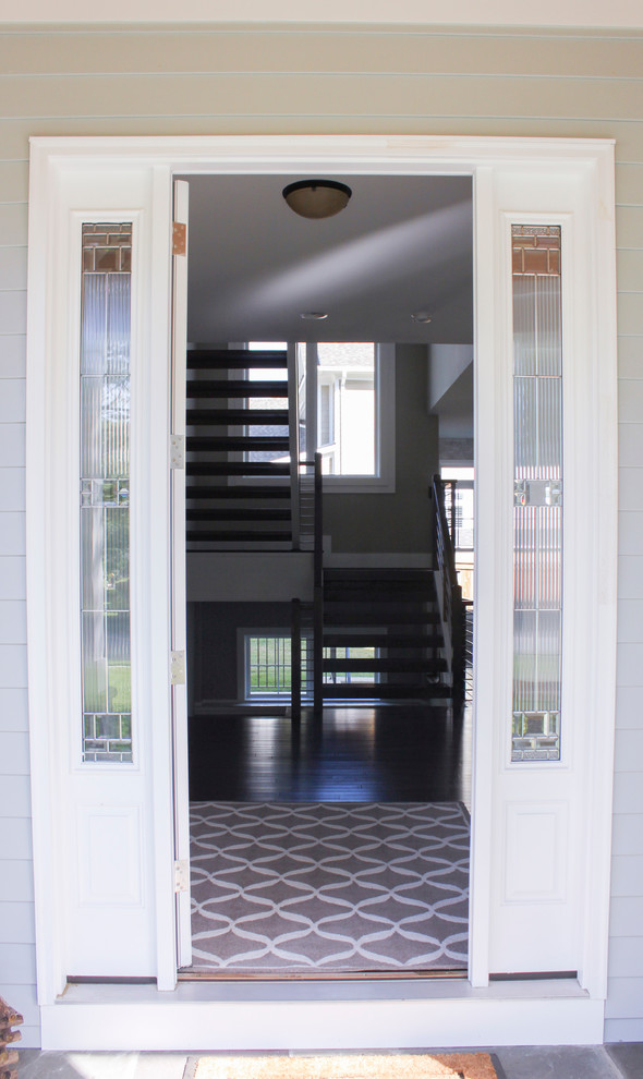 Exemple d'un grand escalier tendance en U avec des marches en bois et un garde-corps en matériaux mixtes.