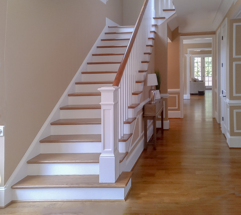 Ejemplo de escalera recta de estilo americano de tamaño medio con escalones de madera, contrahuellas de madera y barandilla de madera