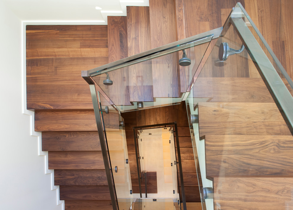 На фото: винтовая деревянная лестница в современном стиле с деревянными ступенями с