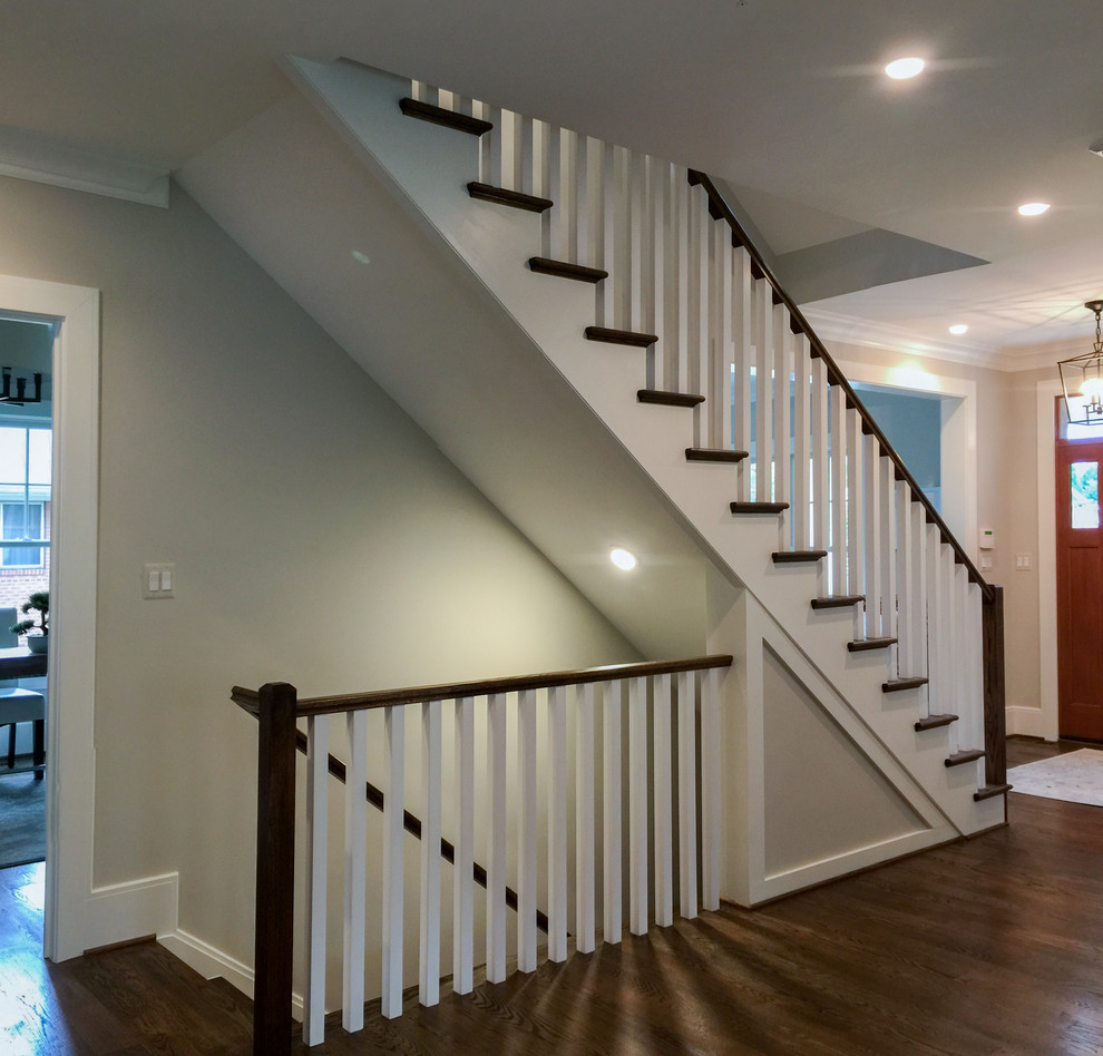 Ejemplo de escalera recta clásica renovada grande con escalones de madera, contrahuellas de madera y barandilla de madera