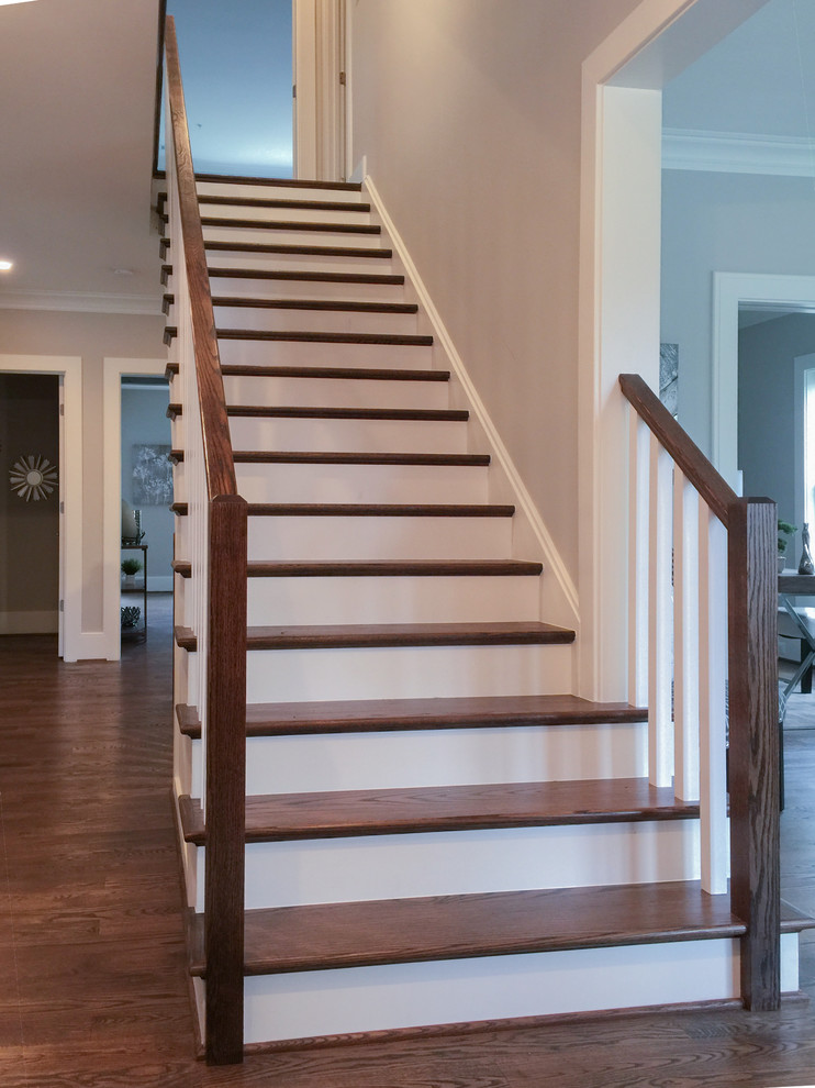 Ejemplo de escalera recta clásica renovada grande con escalones de madera, contrahuellas de madera y barandilla de madera