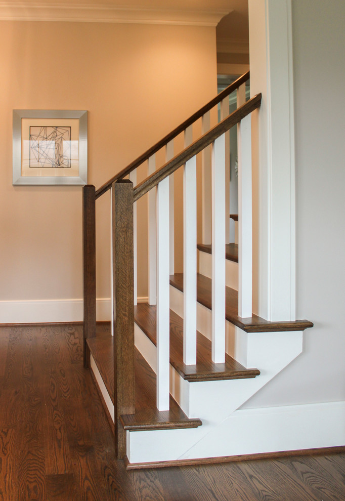 Foto de escalera recta clásica renovada grande con escalones de madera, contrahuellas de madera y barandilla de madera