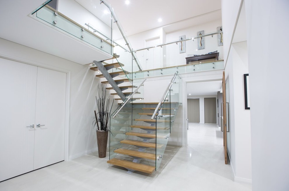 Cette photo montre un escalier sans contremarche moderne en U avec des marches en bois et un garde-corps en verre.
