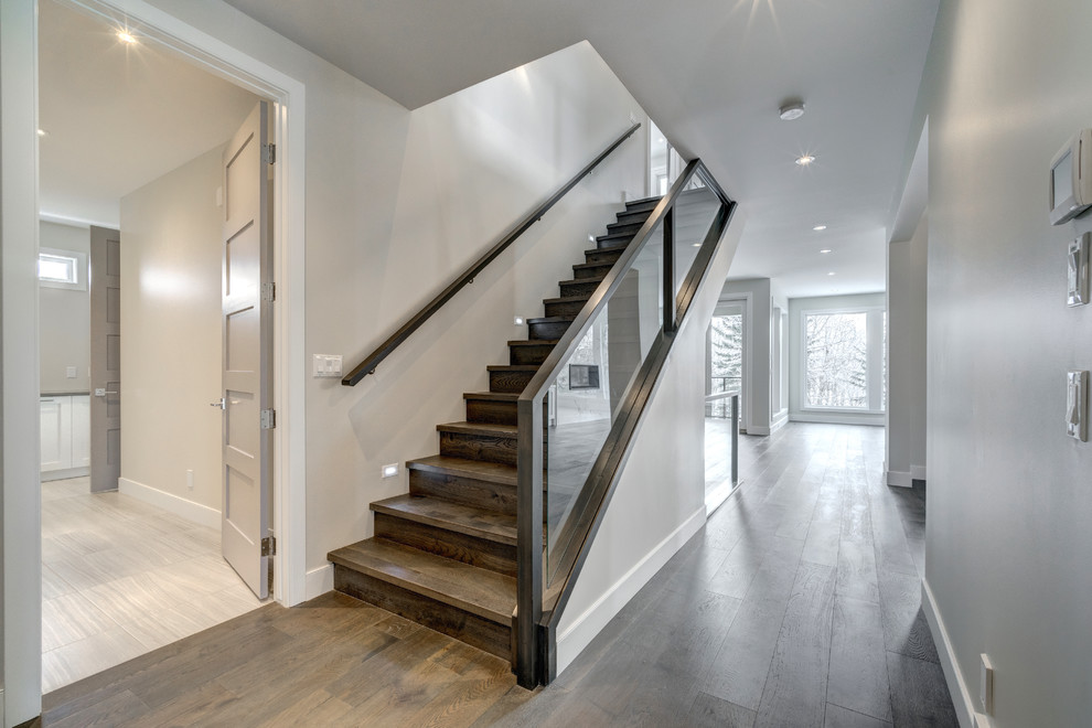Стильный дизайн: большая прямая деревянная лестница в современном стиле с деревянными ступенями и стеклянными перилами - последний тренд