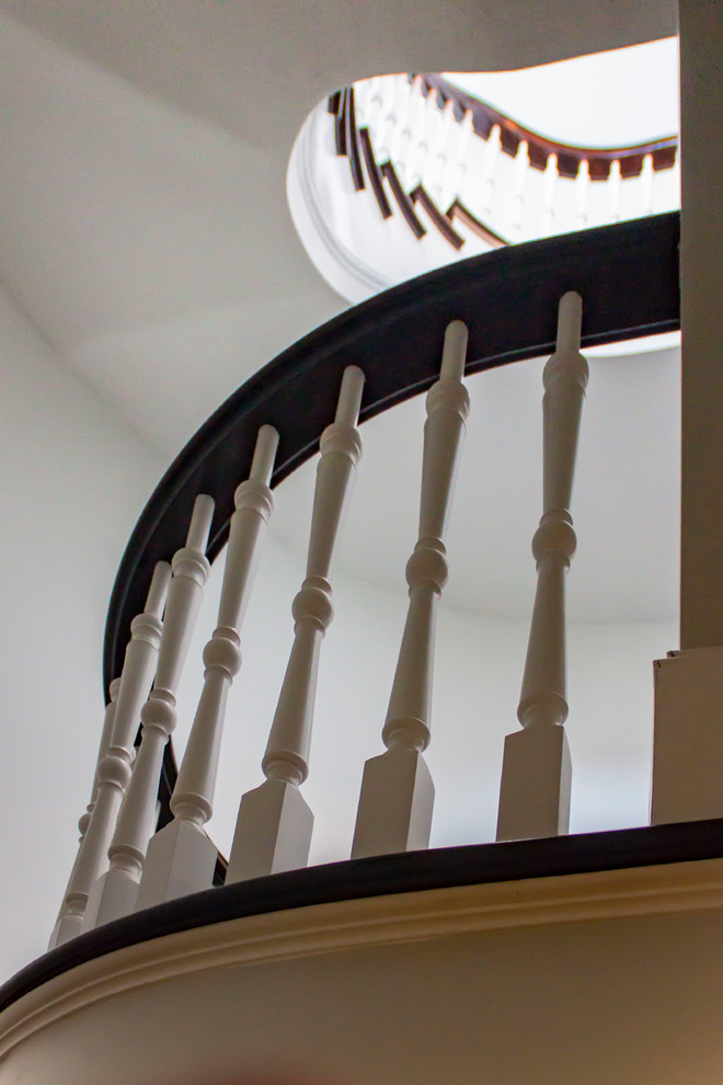 Diseño de escalera de caracol tradicional renovada grande con escalones de madera, contrahuellas de madera y barandilla de madera