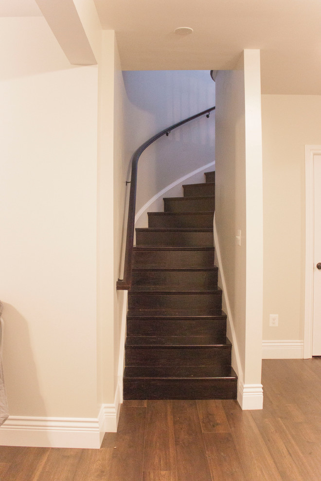 Large transitional wooden spiral wood railing staircase photo in DC Metro with wooden risers
