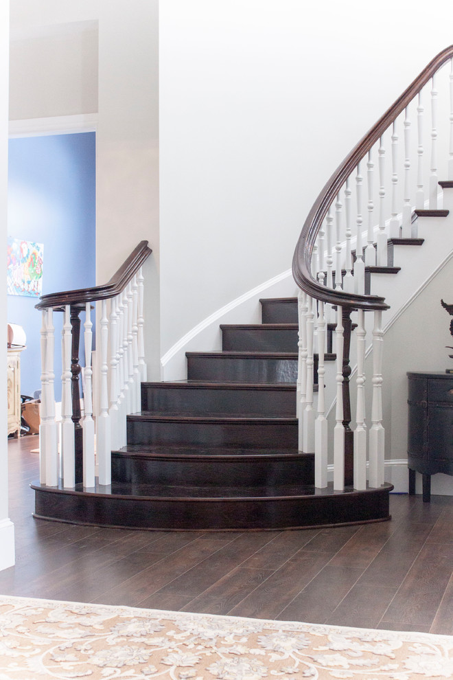 Example of a large transitional wooden spiral wood railing staircase design in DC Metro with wooden risers