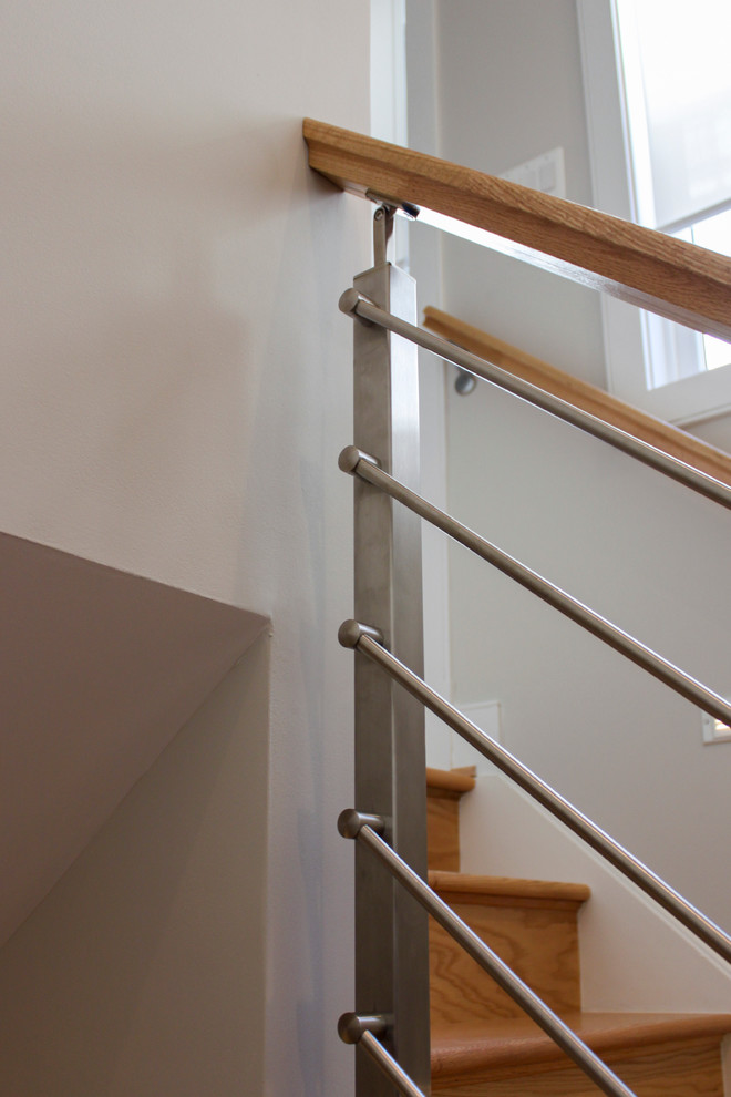 На фото: прямая деревянная лестница среднего размера в современном стиле с деревянными ступенями и перилами из смешанных материалов с
