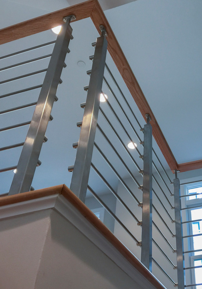 Imagen de escalera recta actual de tamaño medio con escalones de madera, contrahuellas de madera y barandilla de varios materiales