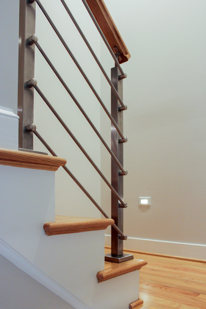 Immagine di una scala a rampa dritta contemporanea di medie dimensioni con pedata in legno, alzata in legno e parapetto in materiali misti