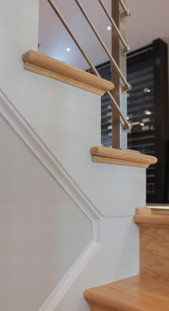 Imagen de escalera recta actual de tamaño medio con escalones de madera, contrahuellas de madera y barandilla de varios materiales