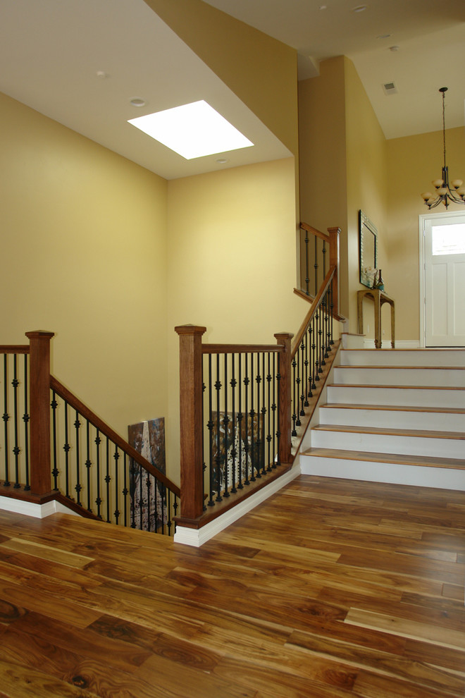 На фото: п-образная лестница среднего размера в стиле кантри с деревянными ступенями и крашенными деревянными подступенками с