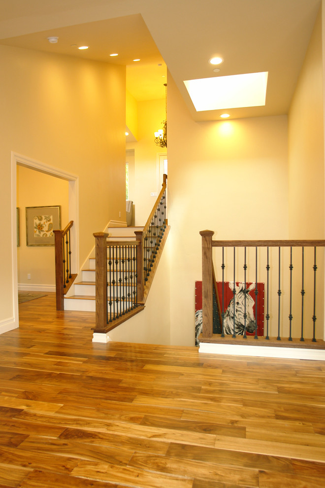 This is an example of a large classic wood u-shaped staircase in San Francisco with painted wood risers.