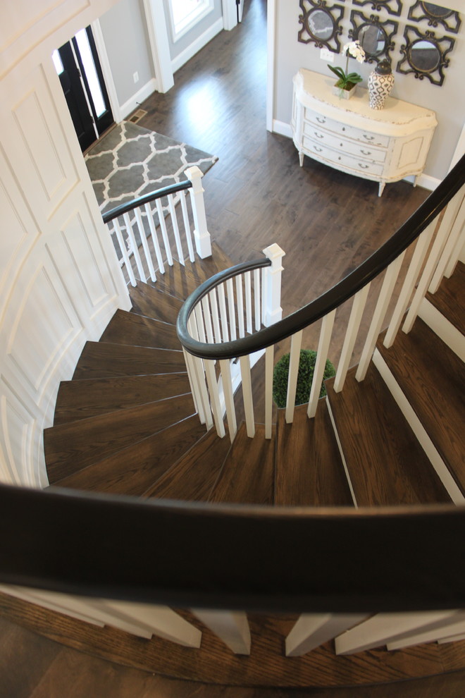 Foto de escalera curva ecléctica extra grande con escalones de madera, contrahuellas de madera y barandilla de madera
