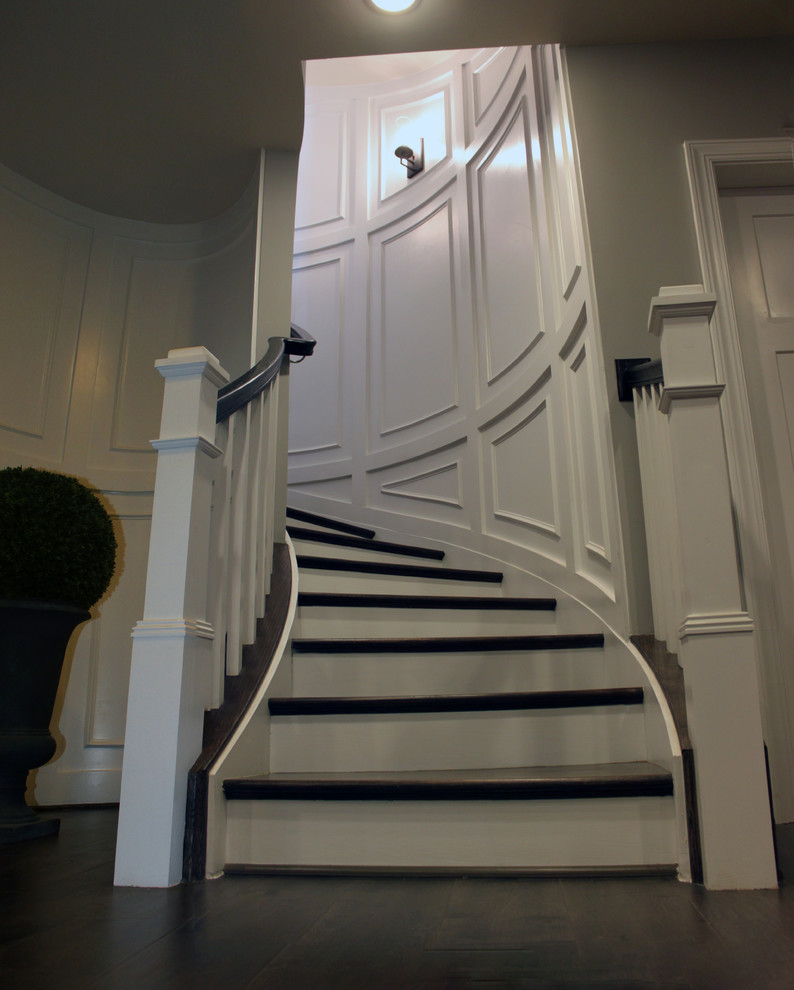 Imagen de escalera curva ecléctica extra grande con escalones de madera, contrahuellas de madera y barandilla de madera