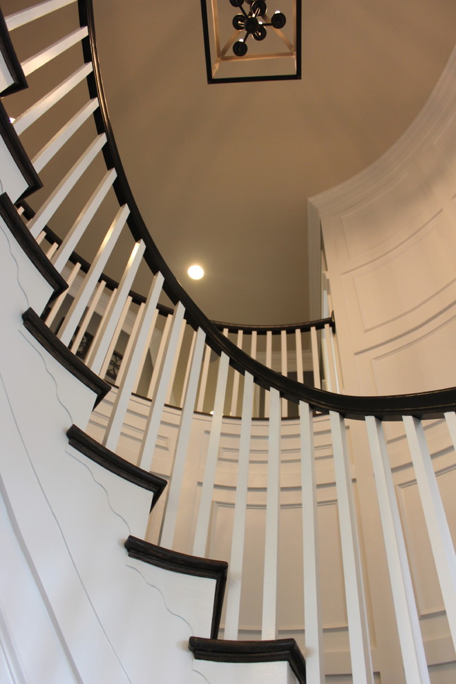 Ejemplo de escalera curva ecléctica extra grande con escalones de madera, contrahuellas de madera y barandilla de madera