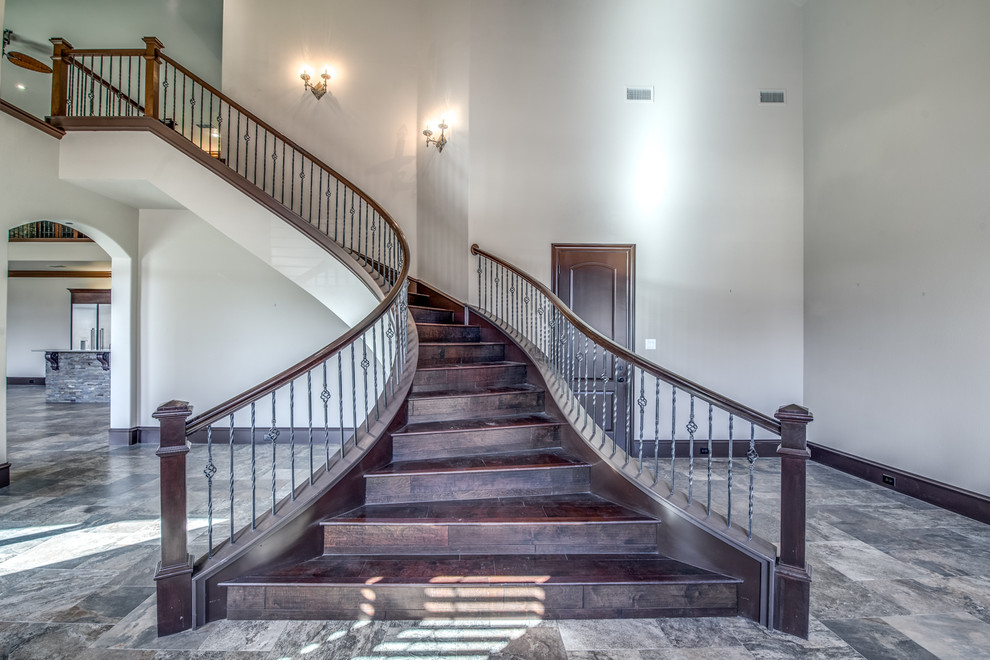 Design ideas for a large mediterranean wood curved mixed railing staircase in Austin with wood risers.