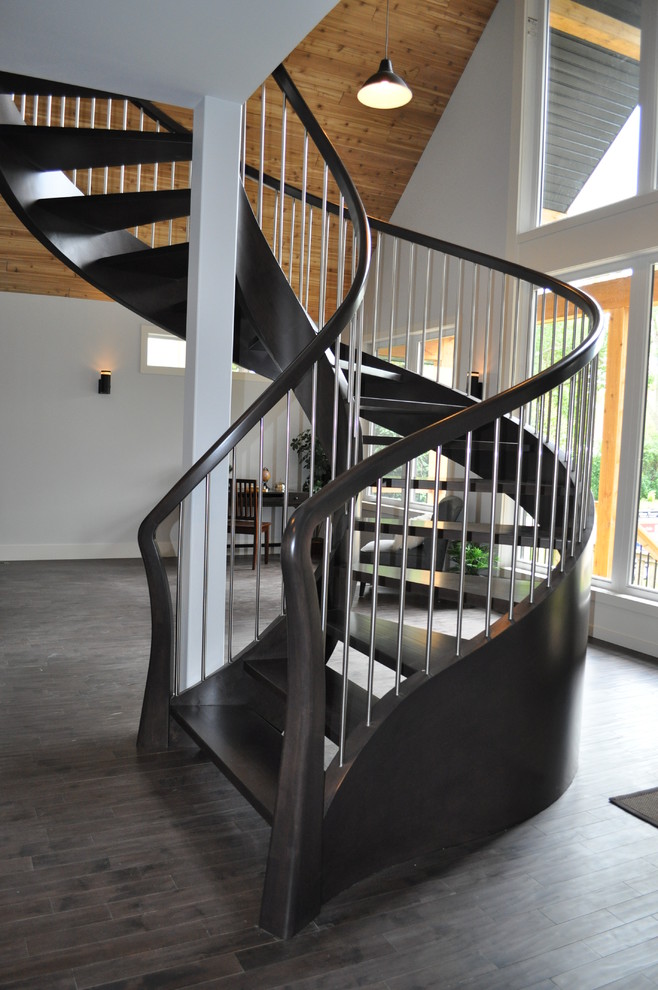 Immagine di una scala a chiocciola minimalista di medie dimensioni con pedata in legno e nessuna alzata
