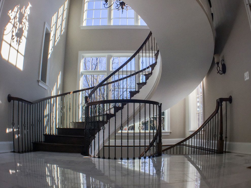 Стильный дизайн: огромная винтовая деревянная лестница в классическом стиле с деревянными ступенями и перилами из смешанных материалов - последний тренд
