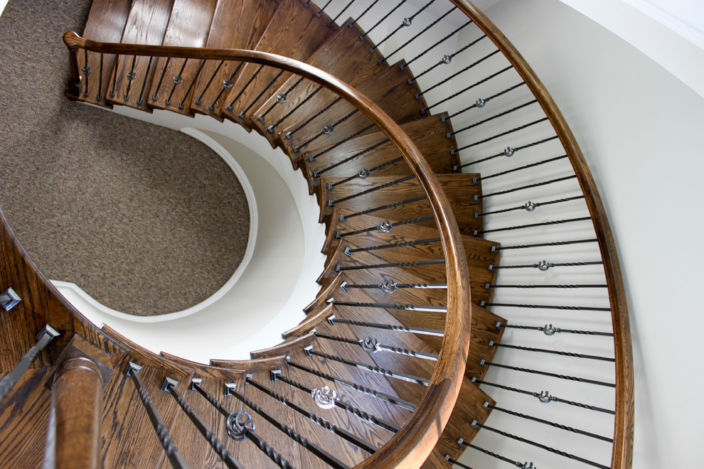 Expansive classic wood spiral mixed railing staircase in DC Metro with wood risers.