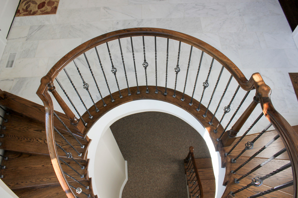 Свежая идея для дизайна: огромная винтовая деревянная лестница в классическом стиле с деревянными ступенями и перилами из смешанных материалов - отличное фото интерьера