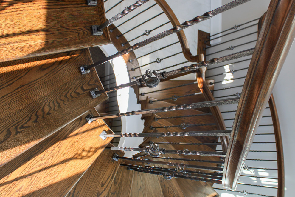 Cette image montre un très grand escalier hélicoïdal traditionnel avec des marches en bois, des contremarches en bois et un garde-corps en matériaux mixtes.