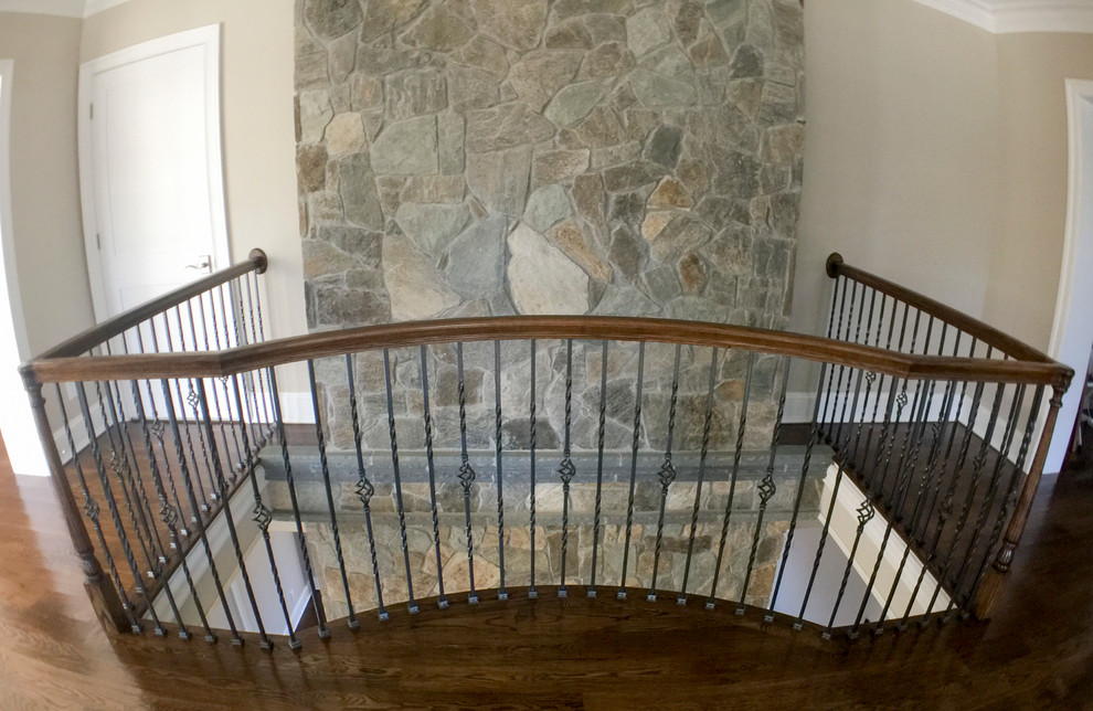 This is an example of an expansive traditional wood spiral mixed railing staircase in DC Metro with wood risers.