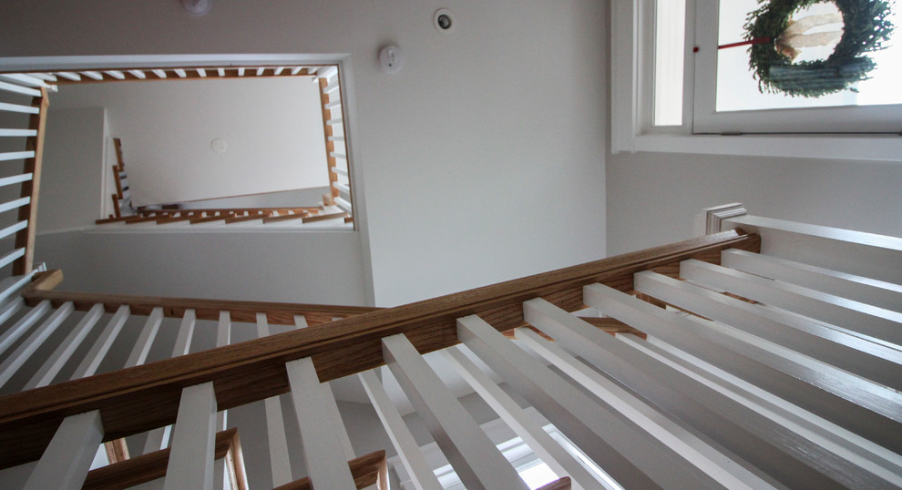 Cette photo montre un grand escalier romantique en L avec des contremarches en bois, des marches en bois et un garde-corps en bois.
